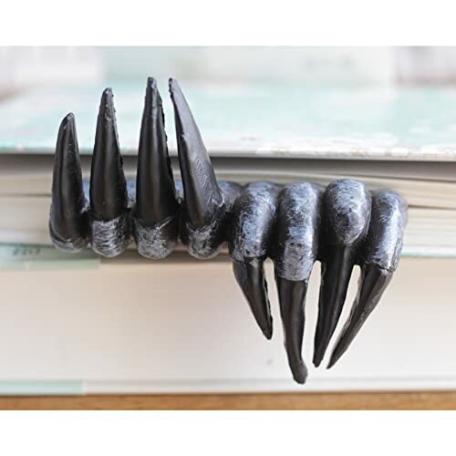 Unique monster claw bookmark on a book